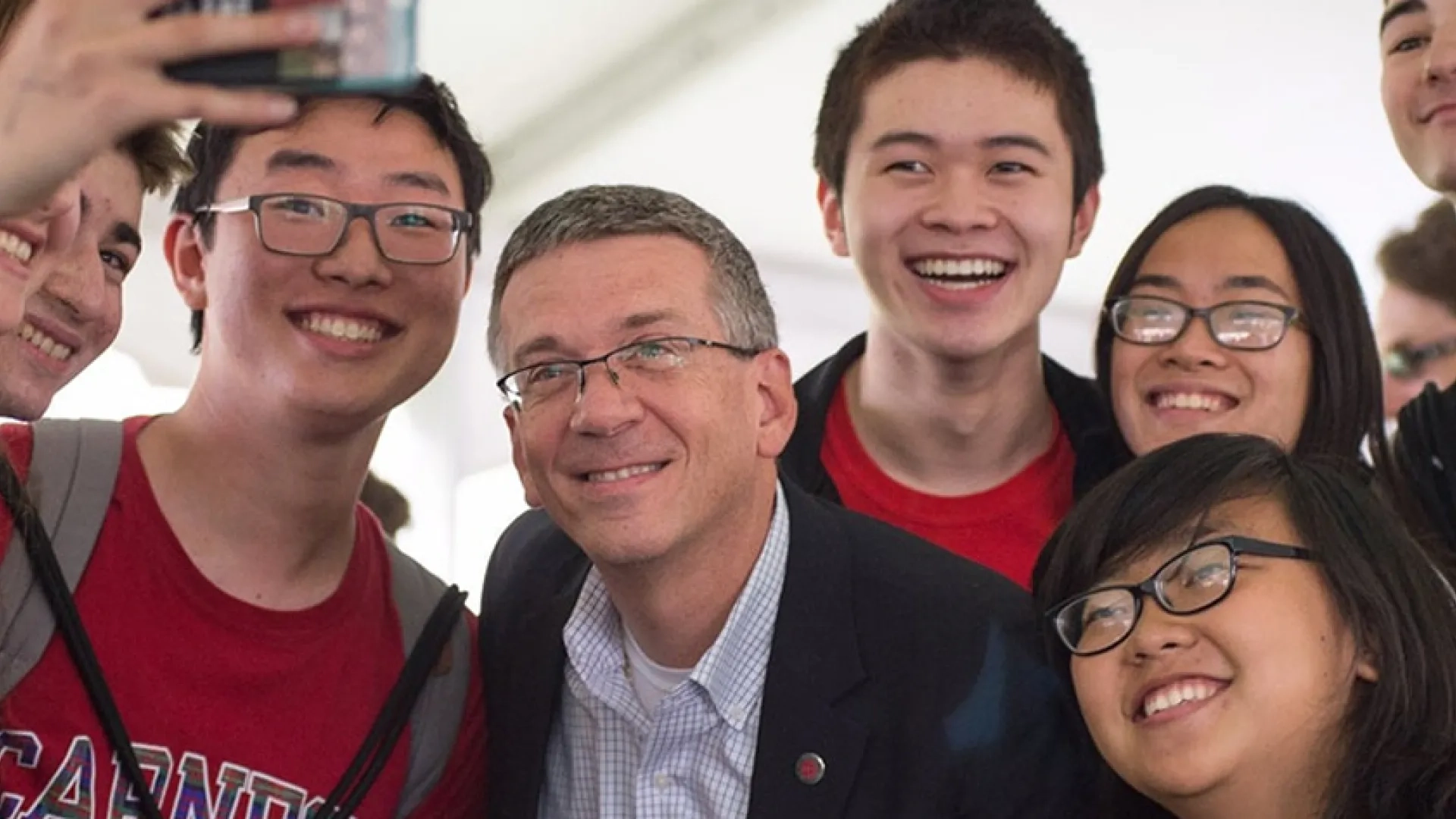Provost Jim Garrett taking a selfie with students.